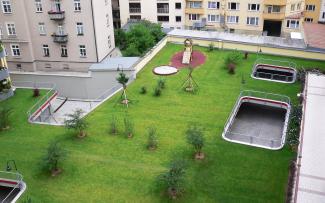 The roof of an underground car park is often visible from all of the surrounding buildings - how nice that it looks so green! Vegetated underground garage with lawn, small trees and playground